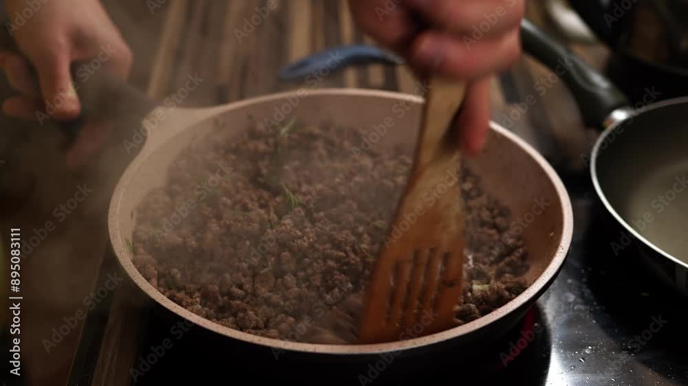 Chef stirs minced meat with rosemary and garlic in a pan with a spatula. High quality 4k footage Chef stirs minced meat with rosemary and garlic in a pan with a spatula. High quality 4k footage