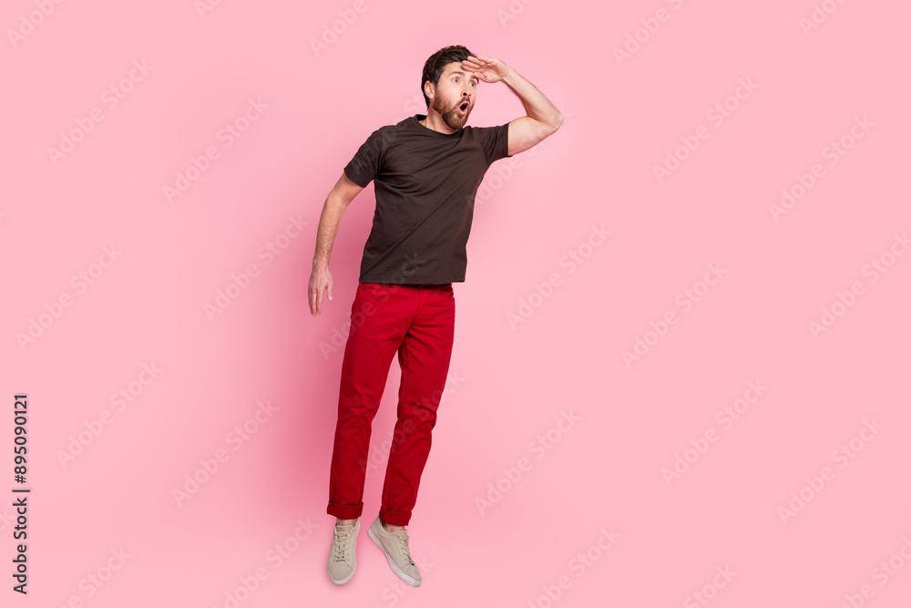 Full length photo of good mood man with bristle dressed brown t-shirt look far at sale empty space isolated on pink color background Full length photo of good mood man with bristle dressed brown t-shirt look far at sale empty space isolated on pink color background