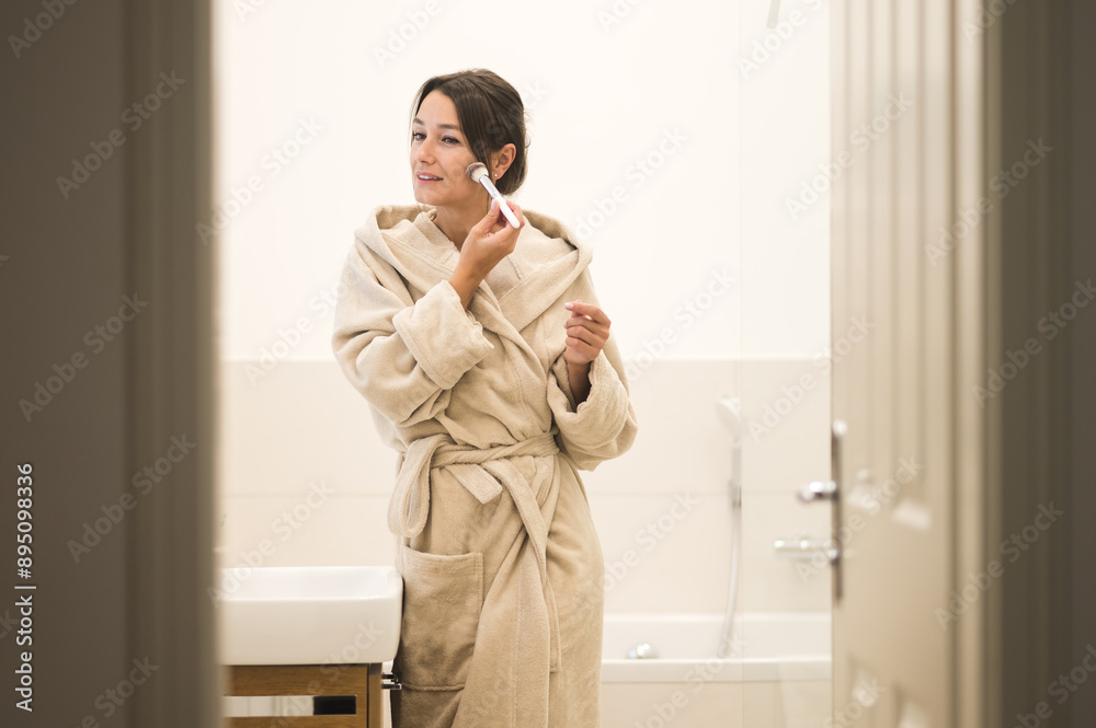 Young smiling woman making make up with a brush and feeling amazing Young smiling woman making make up with a brush and feeling amazing