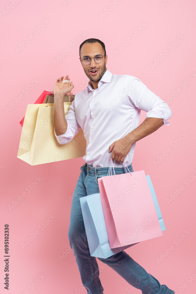 Joyful funny African American man wearing shirt and glasses holding shopping bags Joyful funny African American man wearing shirt and glasses holding shopping bags