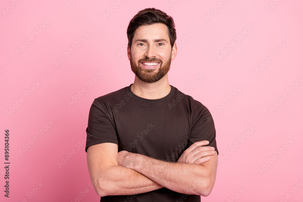 Photo of toothy beaming positive man with stylish bristle dressed brown t-shirt holding arms crossed isolated on pink color background Photo of toothy beaming positive man with stylish bristle dressed brown t-shirt holding arms crossed isolated on pink color background