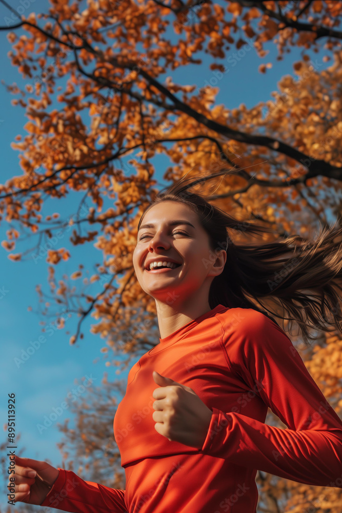 brunette woman in her thirties, smiling and running outdoors under a blue sky with trees in autumn, wearing red sportswear. brunette woman in her thirties, smiling and running outdoors under a blue sky with trees in autumn, wearing red sportswear.