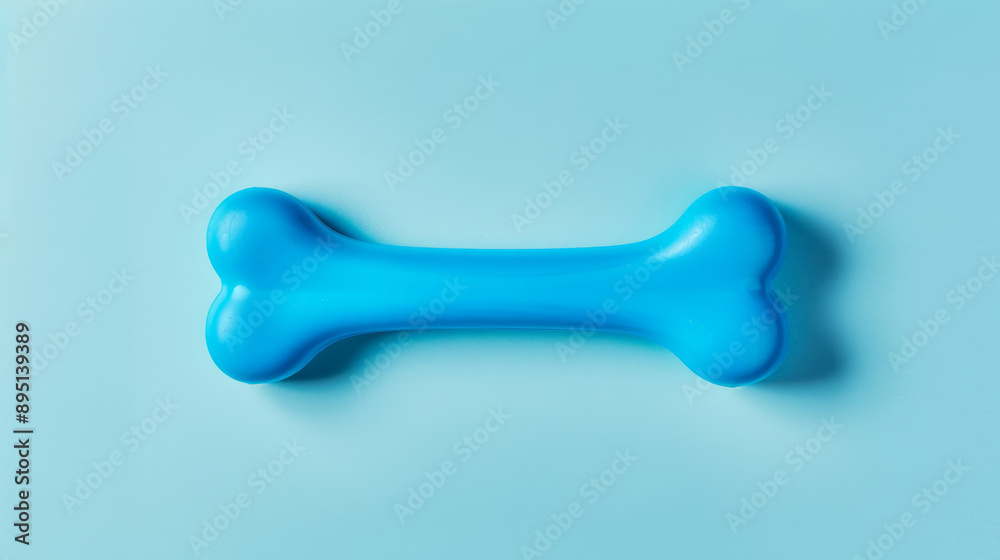 Isolated image of a bright blue chew toy shaped like a bone, on a gradient background Isolated image of a bright blue chew toy shaped like a bone, on a gradient background