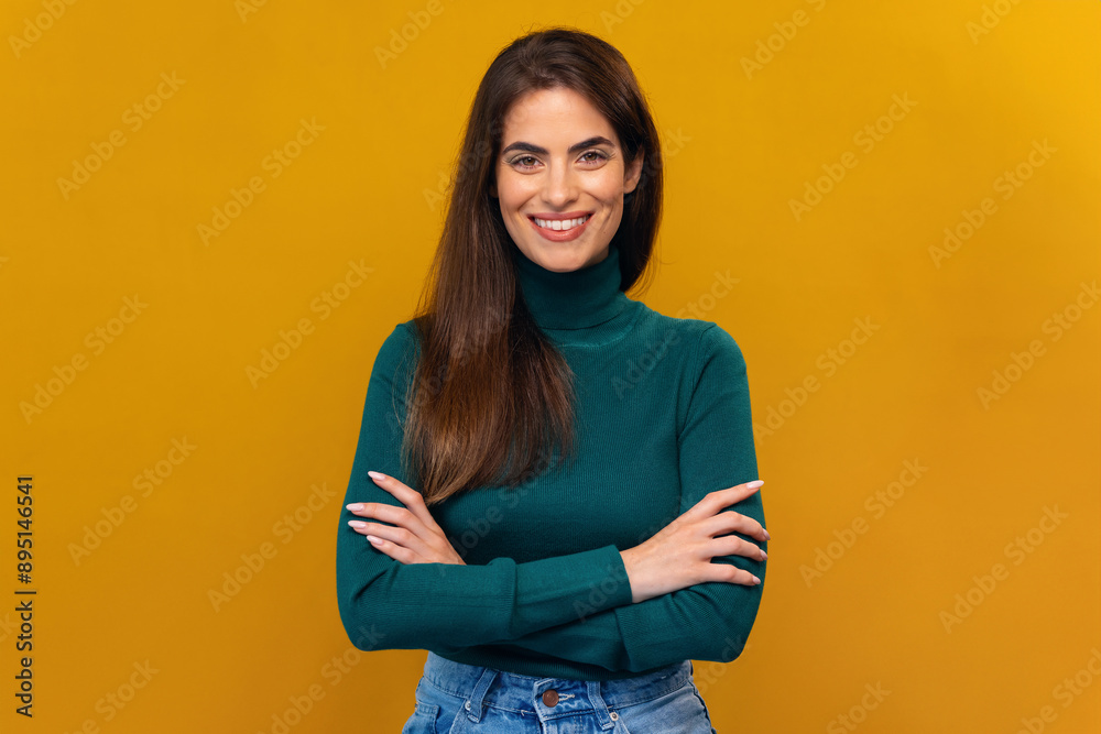 Attractive smiling woman with crossed arms posing at the camera on isolated yellow