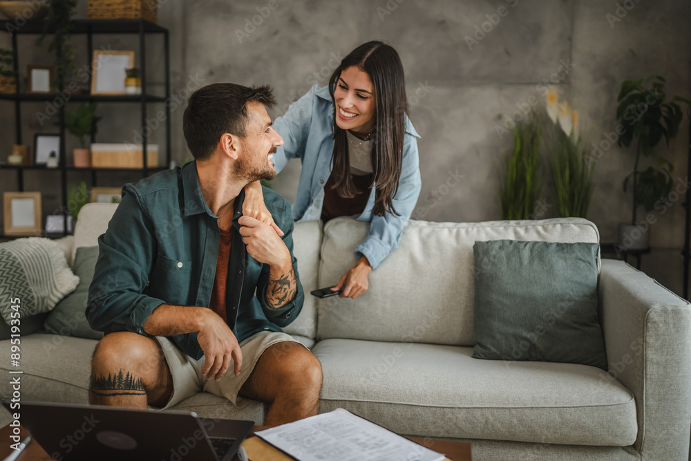 Obraz premium Adult girlfriend take care of her boyfriend while he work from home