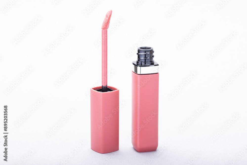 Liquid lipstick with a pink applicator wand against a white background, perfect for use in cosmetics marketing, beauty blogs, or product showcases. Liquid lipstick with a pink applicator wand against a white background, perfect for use in cosmetics marketing, beauty blogs, or product showcases.