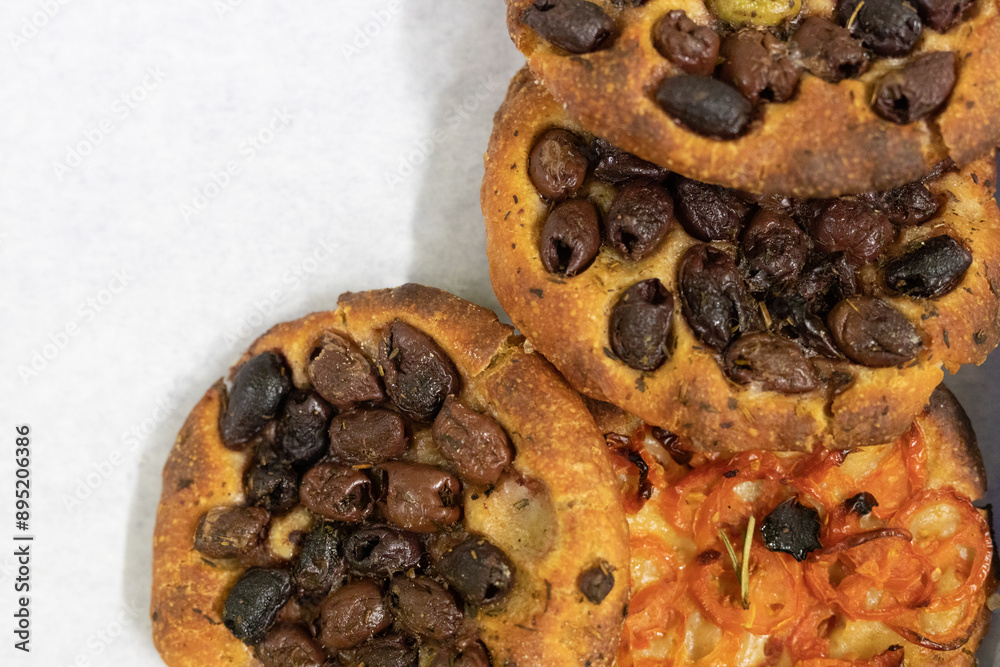 A close up of focaccia bread topped with olives and tomatoes A close up of focaccia bread topped with olives and tomatoes