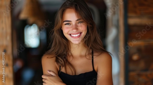 Wallpaper Mural A young woman with long, brown hair and a radiant smile poses confidently in a warmly lit indoor setting. She exudes happiness and confidence. Torontodigital.ca