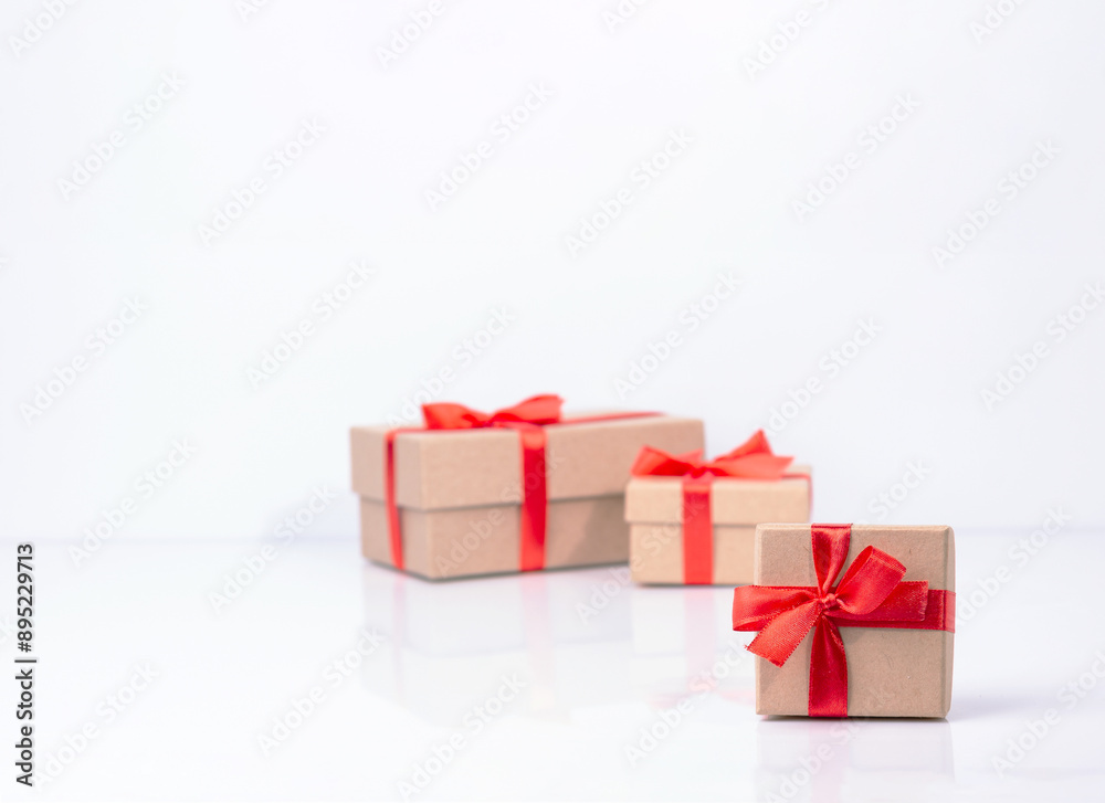 craft gift boxes are tied with red ribbons, there is a place for text on the white glass, selective focus craft gift boxes are tied with red ribbons, there is a place for text on the white glass, selective focus