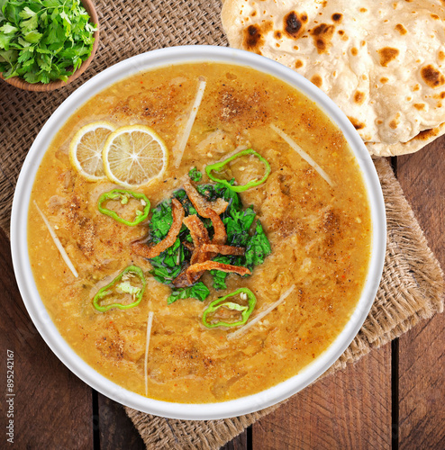 Spicy chicken haleem with fried onion, naan, roti served in dish isolated on background top view of indian spices and pakistani food