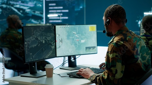 Army intelligence specialist utilize advanced computer systems, surveillance technology and data to enhance national security. Working in a command post against potential threats. Camera A. photo