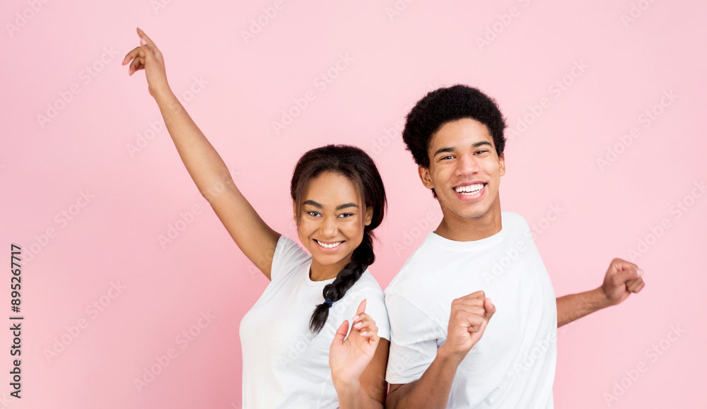 Overjoyed guy and girl dancing and laughing on pink studio background Overjoyed guy and girl dancing and laughing on pink studio background