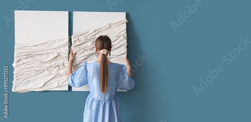 Woman hanging pictures on b...