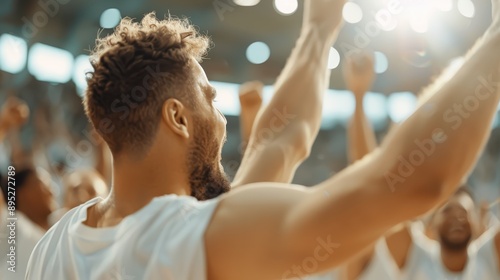 A lively image of an excited audience with raised hands, celebrating in a brightly lit stadium, capturing the joy and energy of a sports event or concert. photo