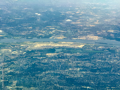 aerial landscape view of area around Philadelphia International Airport (with runways, taxiways and building), Pennsylvania near Delaware River with landscape of state of New Jersey behind the river