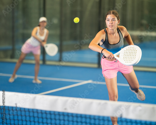 Portrait of cheerful girl paddle tennis player during friendly doubles couple match at court photo