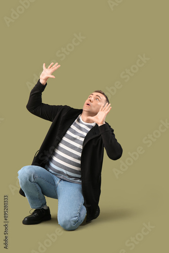 Scared mature man on green ...