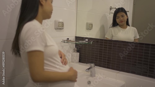 A portrait of happy Asian pregnant woman in toilet,  bathroom or restroom with basin. Having a baby. Family people lifestyle. Mom love.