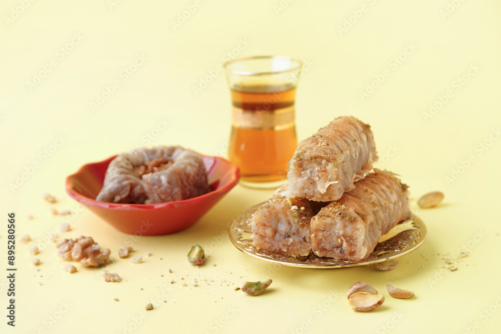 Plate with tasty baklava on yellow background Plate with tasty baklava on yellow background