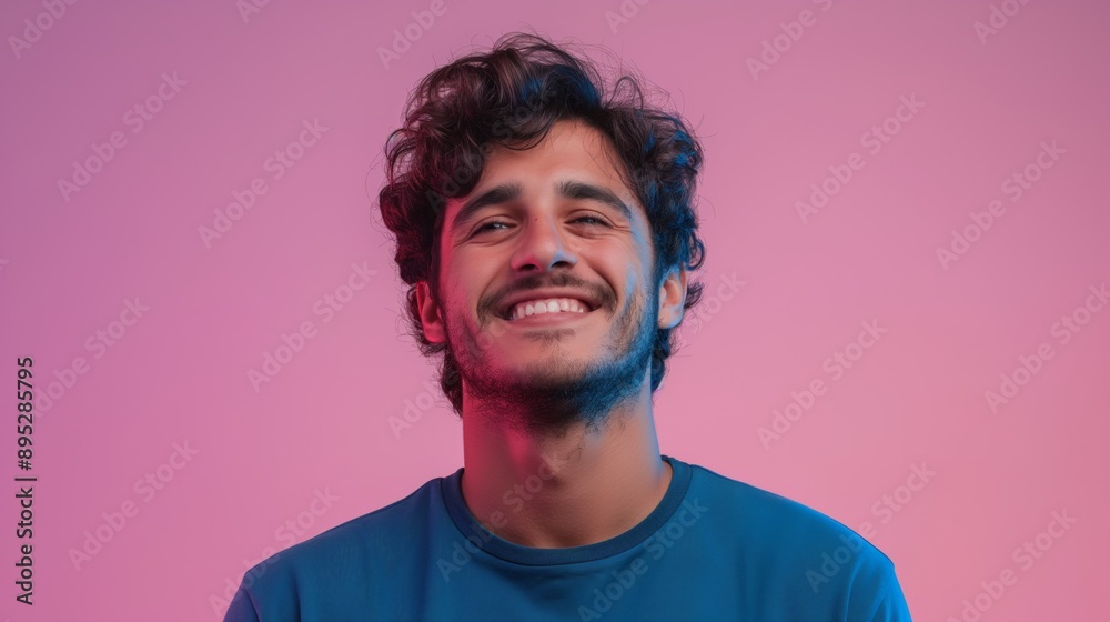 Smiling man with curly hair against pink background. Smiling man with curly hair against pink background.