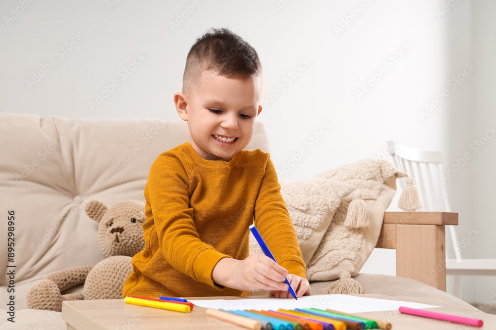 Cute little boy drawing with felt-tip pens on table at home Cute little boy drawing with felt-tip pens on table at home