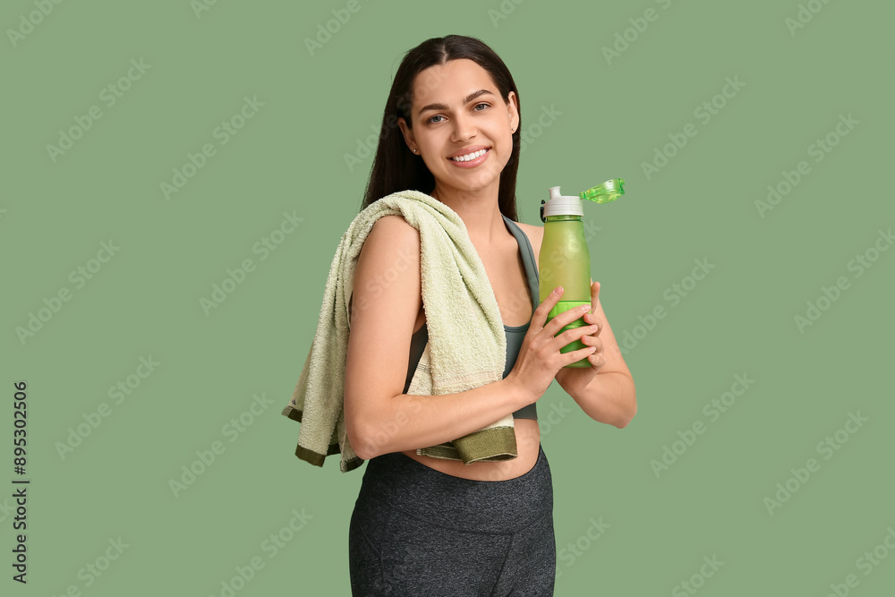 Beautiful young happy woman with towel and sports bottle of water on green background Beautiful young happy woman with towel and sports bottle of water on green background