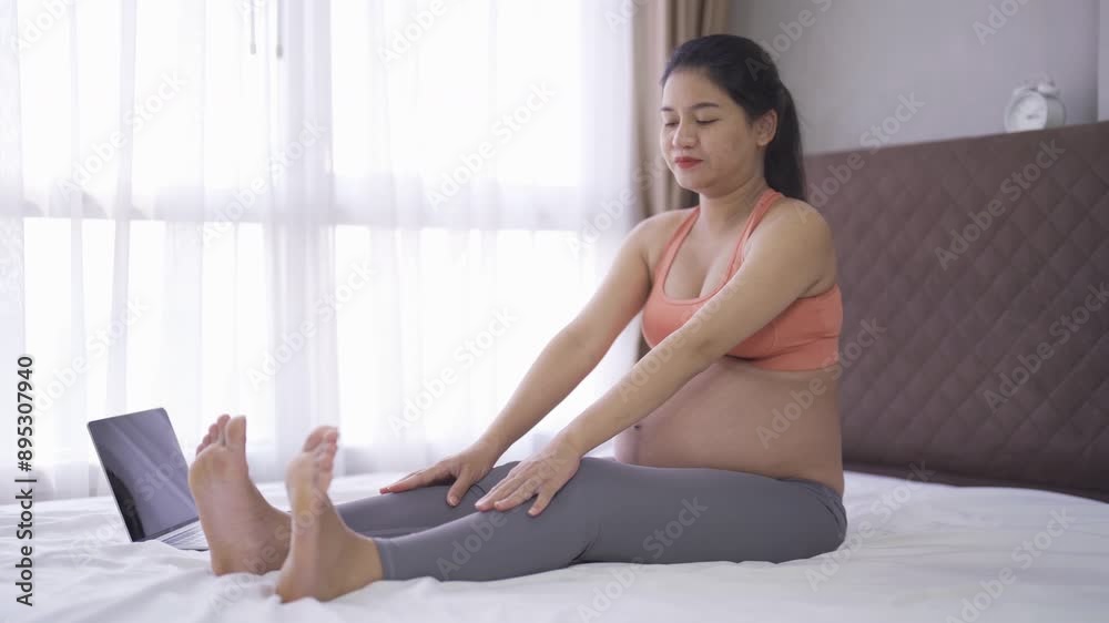 A portrait of happy Asian pregnant woman in bedroom at home. Having a baby. Training workout. Exercise indoor with sport equipment. Athletic. Family people lifestyle. Mom love. Recreation.