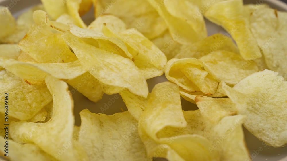 Serving many homemade circular potato chips on a gray ceramic plate, slow motion