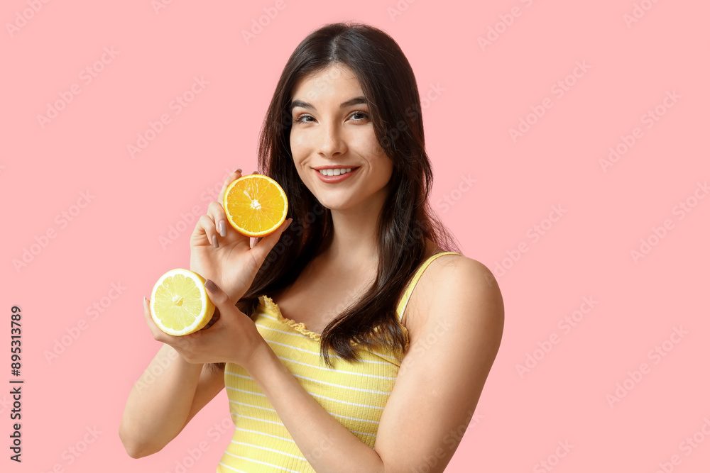 Beautiful young woman with orange and lemon on pink background
