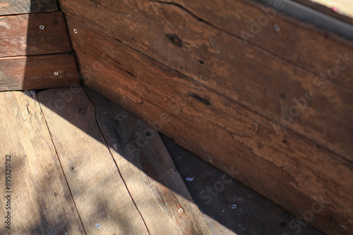 Wooden floors in corners decorate the exterior under sunlight and shadow. Outdoor wallpaper. Light and dark brown shades.  photo