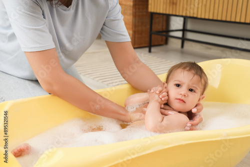 Mother bathing her baby in ...