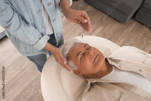 Hypnotherapy and mental wellness, therapist using a pendulum for relaxation a...