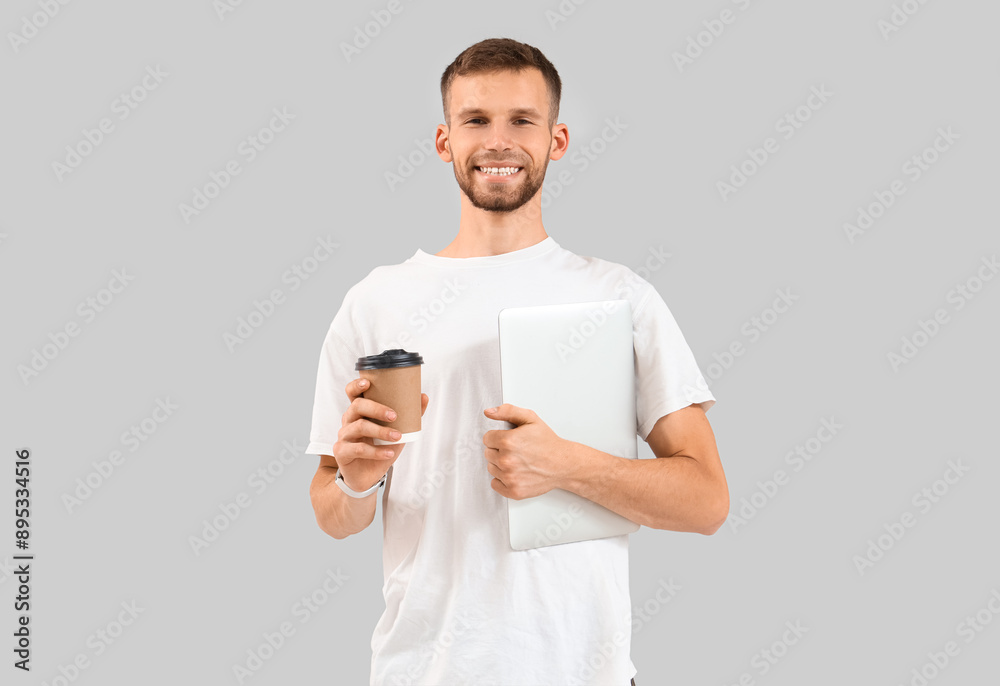 Handsome man with laptop and coffee cup on light background Handsome man with laptop and coffee cup on light background