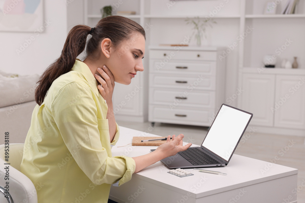 Sick woman having online consultation with doctor via laptop at white table indoors Sick woman having online consultation with doctor via laptop at white table indoors