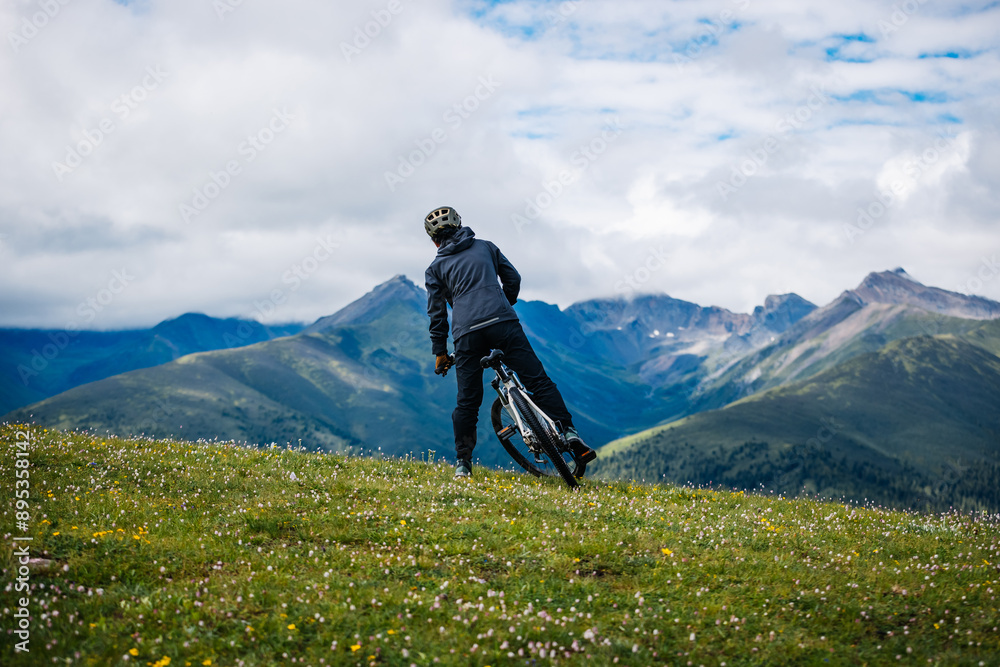 Riding mountain bike on grassland mountain top Riding mountain bike on grassland mountain top