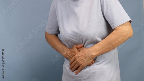 Close up of an elderly person suffering from abdominal pain