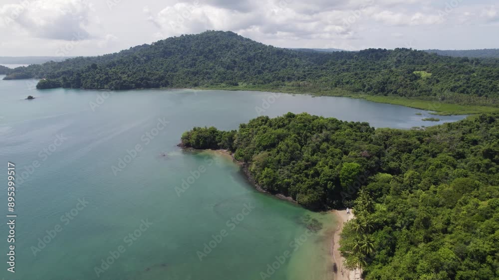 Aerial view of the serene Coiba Island beach in Panama, showcasing lush greenery, clear waters, and anchored boats. pull back shot Aerial view of the serene Coiba Island beach in Panama, showcasing lush greenery, clear waters, and anchored boats. pull back shot