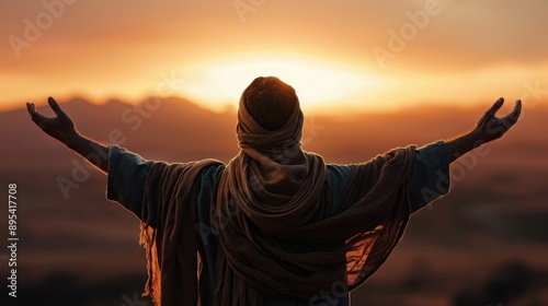 A person in traditional attire standing with arms raised before a stunning sunrise, symbolizing freedom, peace, and spirituality.