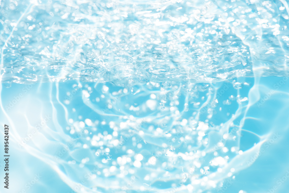 Blue water with ripples on the surface. Defocus blurred transparent blue colored clear calm water surface texture with splashes and bubbles. Water waves with shining pattern texture background. Blue water with ripples on the surface. Defocus blurred transparent blue colored clear calm water surface texture with splashes and bubbles. Water waves with shining pattern texture background.