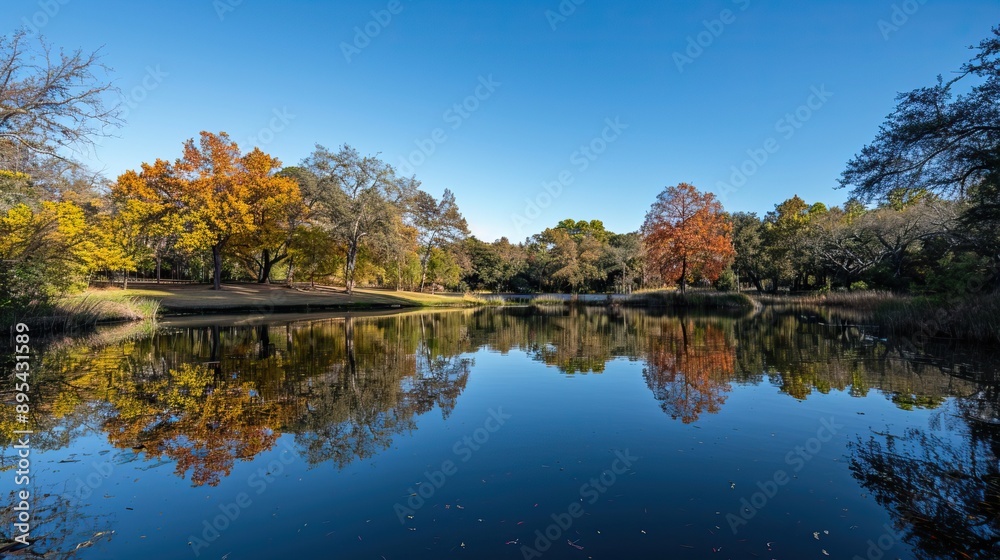 Lake surrounded by autumn trees and a wooden dock reflecting in the water Lake surrounded by autumn trees and a wooden dock reflecting in the water