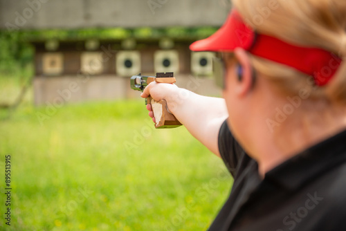 A dedicated female athlete, renowned for her precision and discipline, practices during a sports shooting training session, preparing meticulously for an upcoming competition. photo