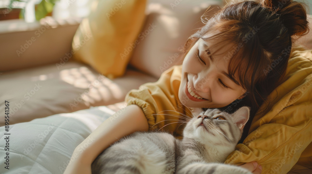 A happy Asian woman playing with her Scottish Fold cat in the living room, showcasing the bond between pet owner and pet A happy Asian woman playing with her Scottish Fold cat in the living room, showcasing the bond between pet owner and pet