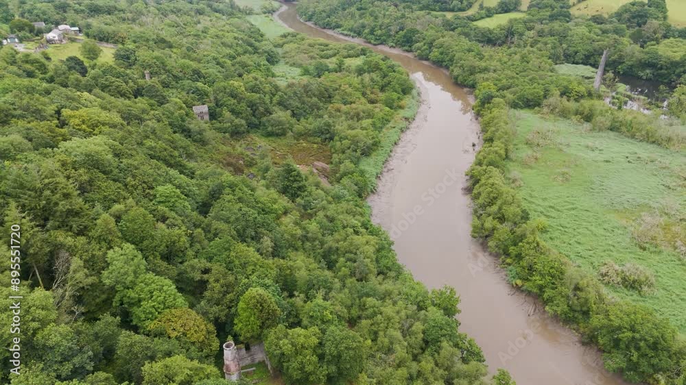 Aerial rising view of Cornish tin and copper mine ruins nestled along the banks of the river Tamar surrounded by green woodland Aerial rising view of Cornish tin and copper mine ruins nestled along the banks of the river Tamar surrounded by green woodland