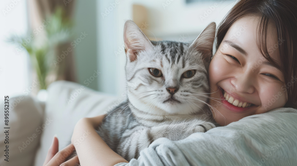 Asian woman with a big smile, cuddling her Scottish Fold cat in the living room, depicting a loving pet relationship Asian woman with a big smile, cuddling her Scottish Fold cat in the living room, depicting a loving pet relationship