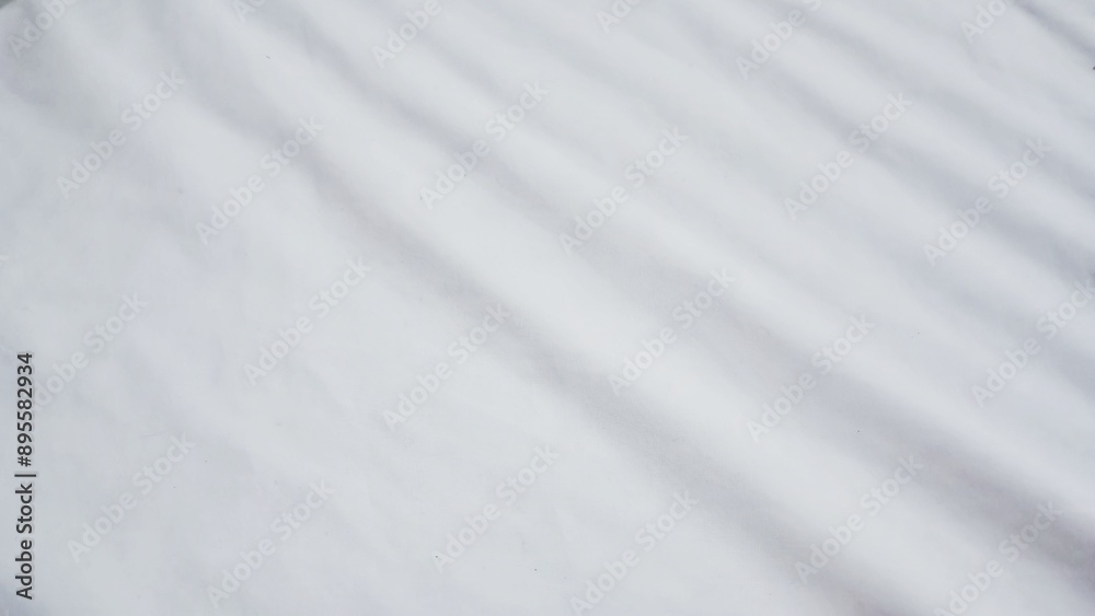 Abstract pattern of white crumpled bed sheet. White wrinkled fabric texture rippled surface. Close up image. Abstract pattern of white crumpled bed sheet. White wrinkled fabric texture rippled surface. Close up image.