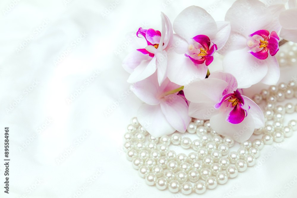 The branch of purple orchids on white fabric background The branch of purple orchids on white fabric background