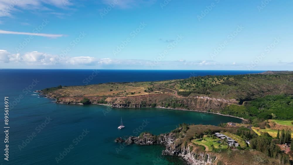 Drone shot of yacht anchored in tropical bay with rocky outcroppings and ocean horizon Drone shot of yacht anchored in tropical bay with rocky outcroppings and ocean horizon