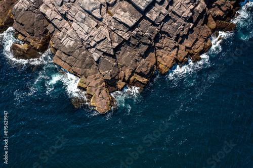 top view of the sea waves beating against the rocky shore