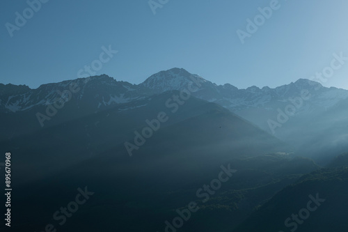 Foggy and snowy mountain view from Mestia village of Svaneti. Magnificent nature of Georgia. Foggy and snowy mountains and hills.