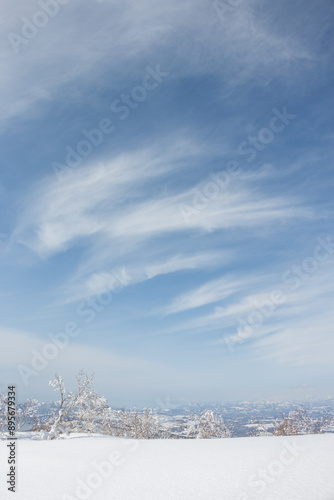 White clouds in winter sky above frozen snow landscape in Hokkaido Japan photo